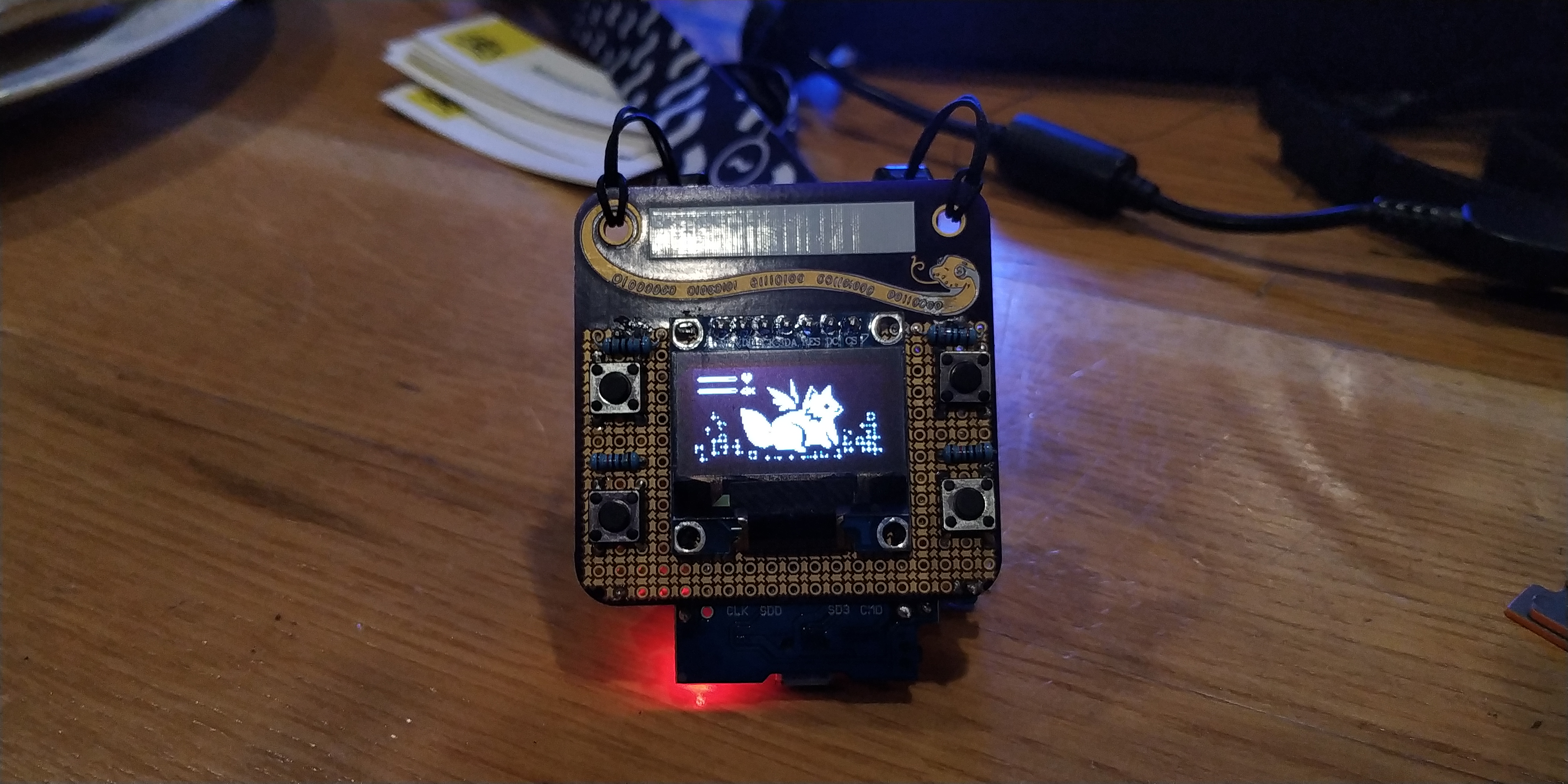 The tamafoxi prototype, on an SMD protoboard with a screen that shows an active fox